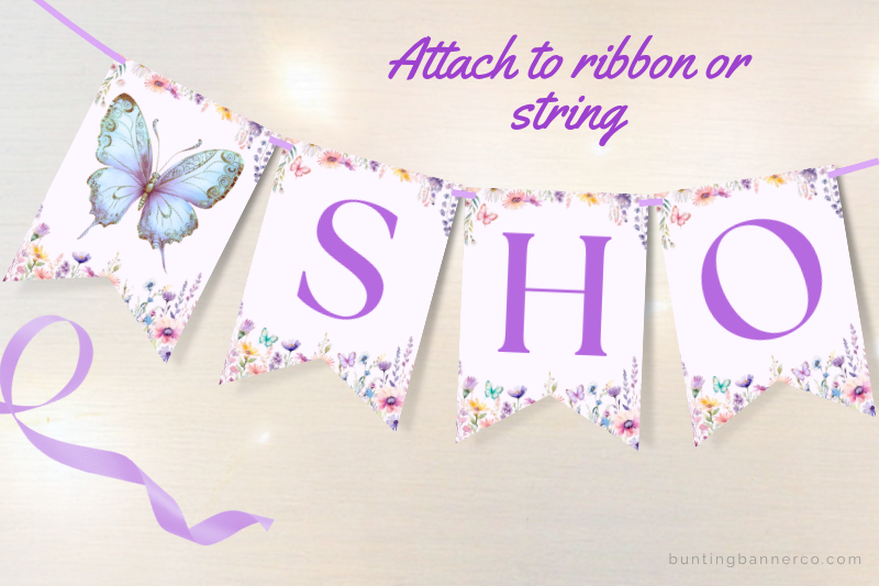 Baby shower bunting flags with butterflies, flowers and purple letters.