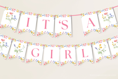 Hanging It's A Girl wildflower baby shower banner with watercolor wildflowers and foliage.